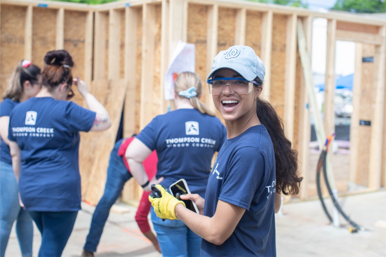Employees in good standing are paid to perform community service like Carmen here. She's helping to build a new home for Habitat for Humanity with co-workers from throughout Thompson Creek.