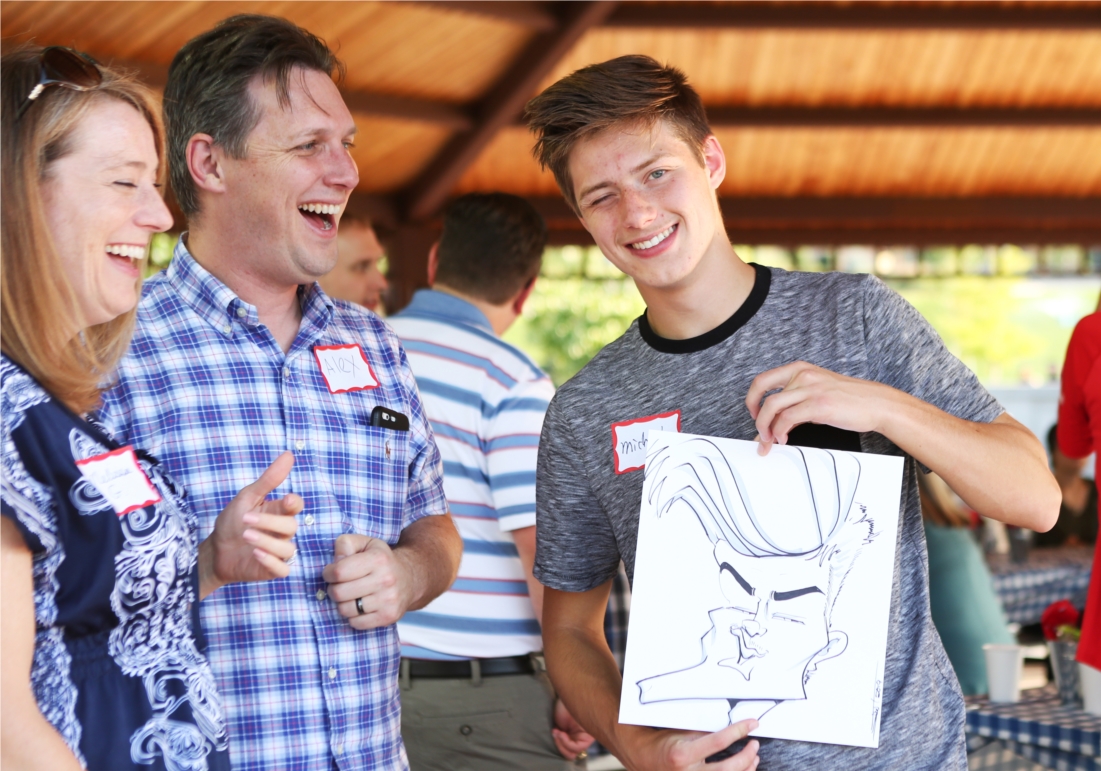 Son of an employee displays his characiture at the company picnic. 