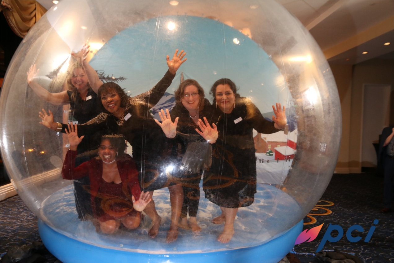 PCI staff at the 2020 Holiday Party.  Front Row (kneeling) Jonne Winfree (SAFe Consultant):  Back Row (from left to right): Mindy Shackelford (Accounts Payable Accountant), Paulette Goodwin (Payroll Administrator), Trish Maxfield (DoD Executive Officer), and Monica Chohda (Finance Administrator).