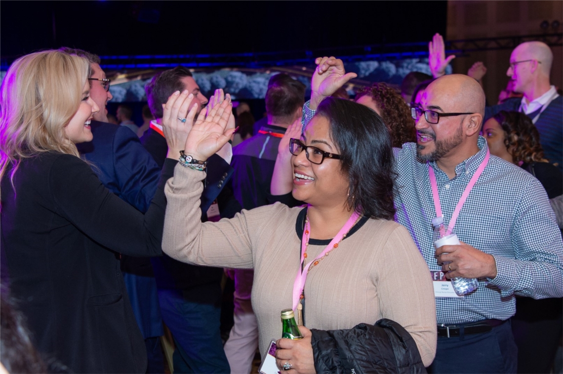 Horizon employees greet each other with enthusiasm at a company meeting.