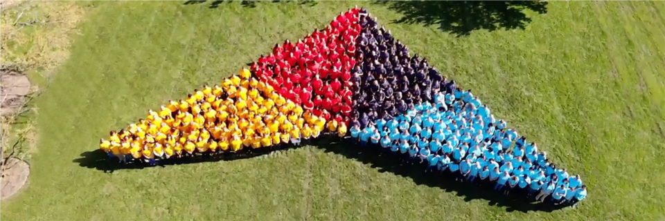 Nearly 500 associates in Lake Forest sport four different color t-shirts to form a human model of Trustmark’s new visual icon.