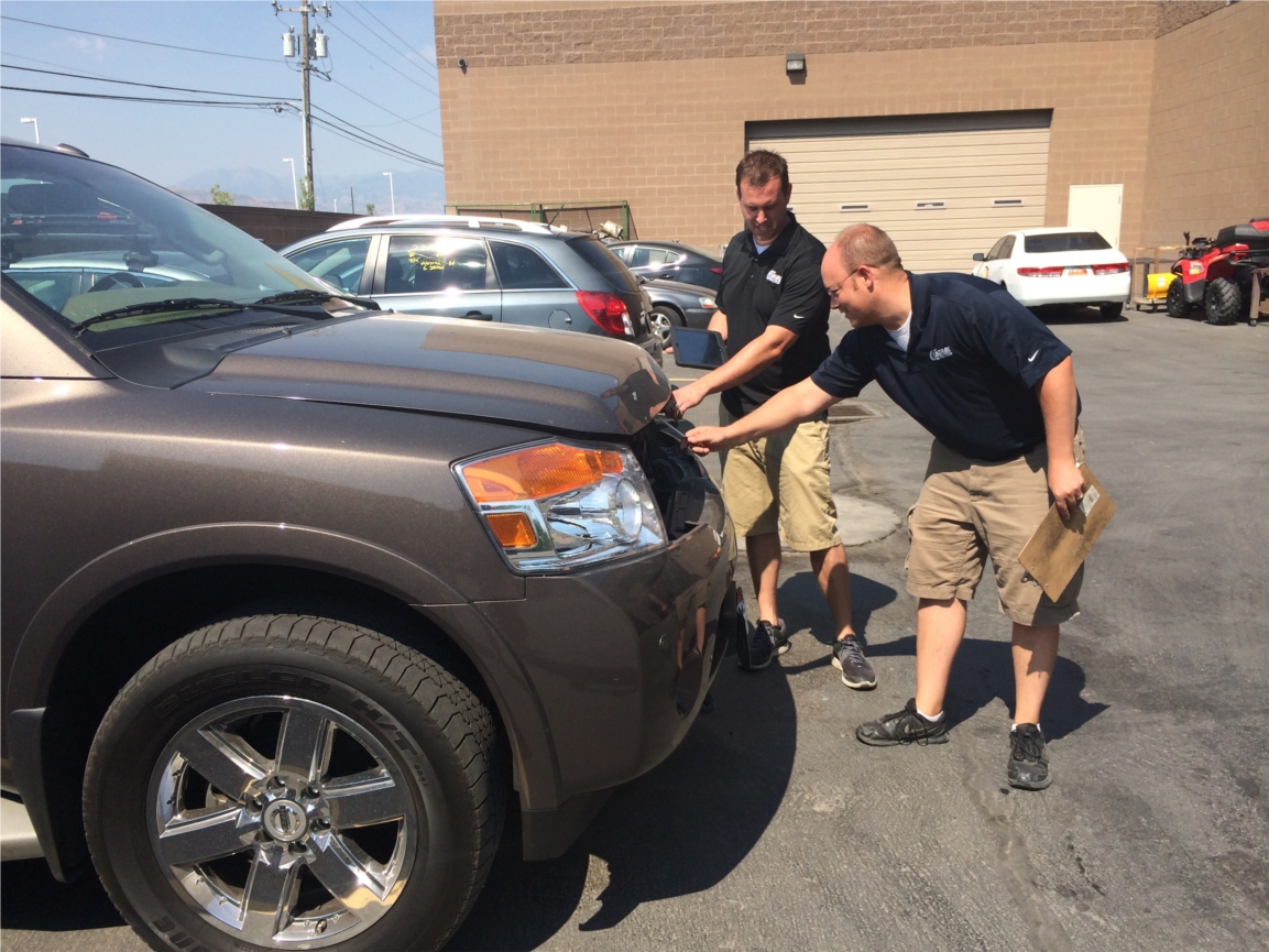 Brandon Danielson and Brandon Naef, estimators at our Draper location, looking over damage on a vehicle. 