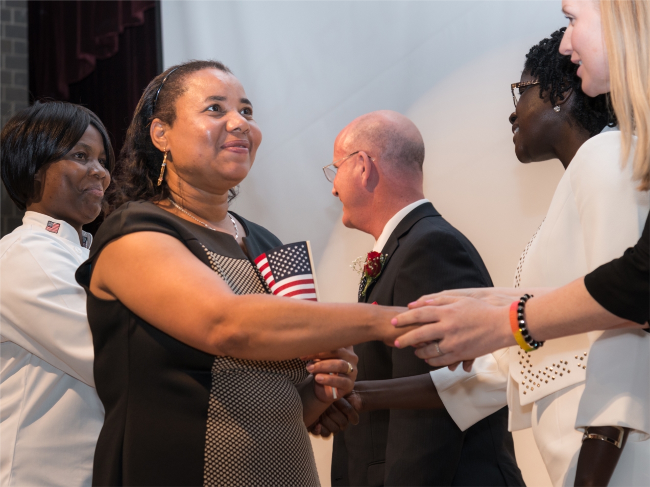 New citizens walk across the stage during the 2016 graduation ceremony. The Carlos Rosario School citizenship program prepares students to pass the test to become naturalized citizens.