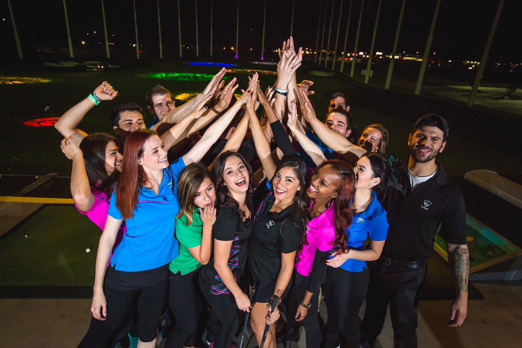Topgolf Associates high-fiving. Topgolf's Associate rewards and recognition platform is called The High-Five Zone.