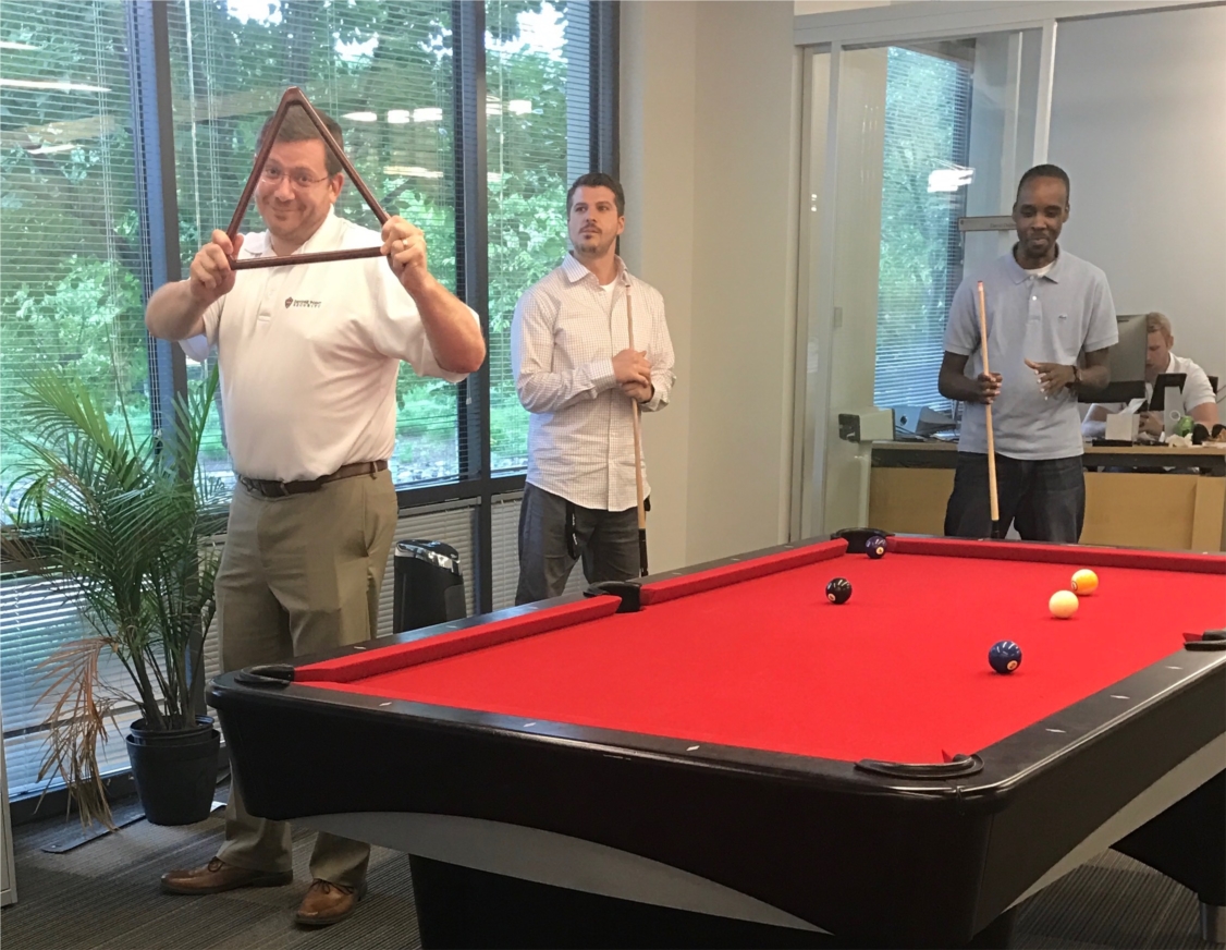 DPS Community members playing pool during our quarterly LAN Party where the DPS community gathers for fun, games, and presentations on the latest cybersecurity trends or R&D projects.